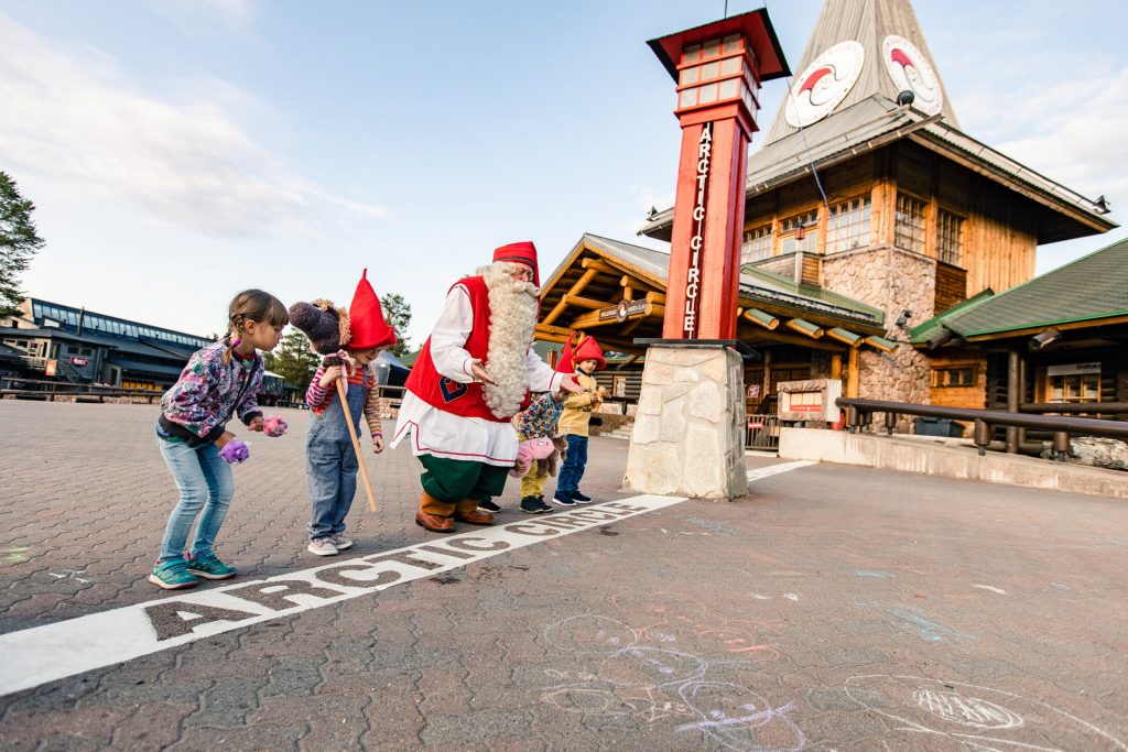 Santa Claus playing with kids on the Arctic Circle at Santa Claus Village in Rovaniemi Lapland Finland.
